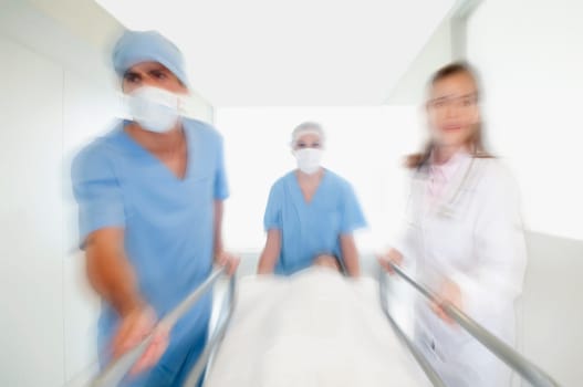 Doctors pushing a patient on a hospital Gurney in a hospital corridor