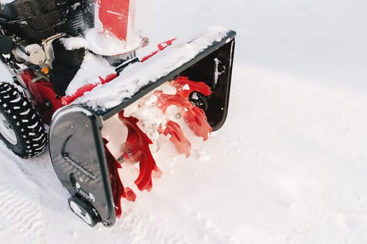 Red-black snowblower machine in the process of work. High quality photo