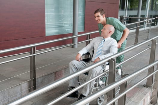 Male nurse pushing a man in wheelchair