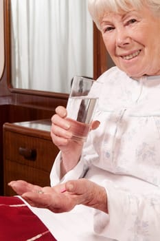 Woman sitting on the bed and taking medicine