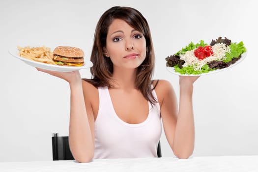 Woman choosing between a hamburger and salad