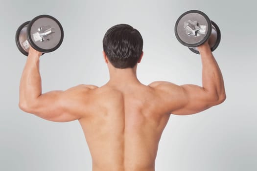 Rear view of a man exercising with dumbbells