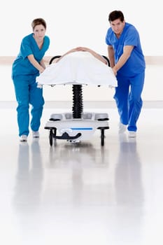 Two doctors pushing patient on a gurney