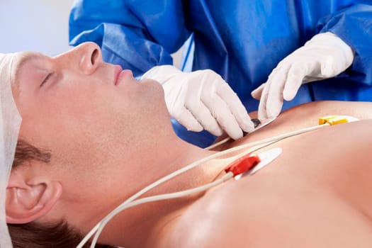 Surgeon attaching ECG electrodes on patientŽs chest