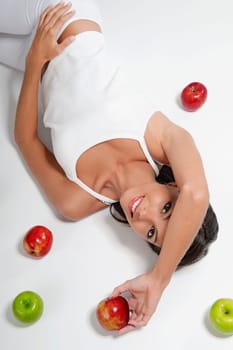 High angle view of a woman lying with red and green apples