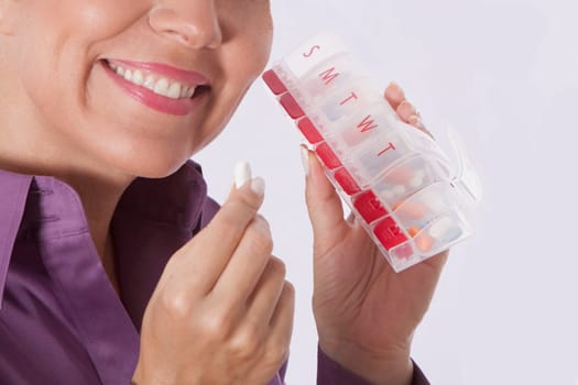 Woman taking medicine from a pill box