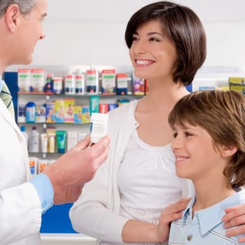 Male pharmacist giving medicine to customers