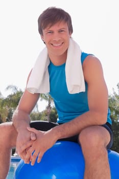 Man sitting on a fitness ball and smiling