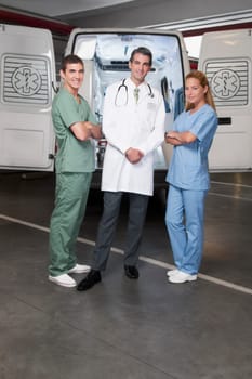 Doctor with co_workers standing in front of an ambulance