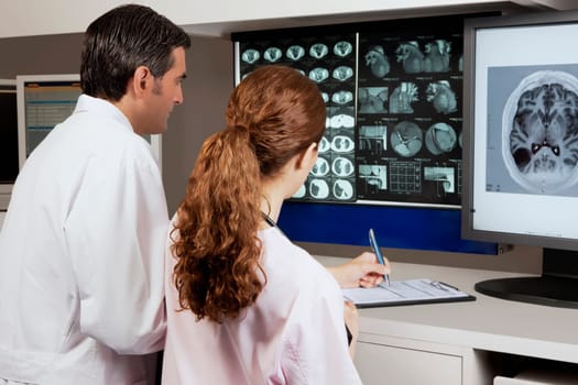 Two doctors examining MRI report