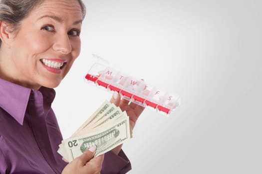 Woman holding pills box and currency notes