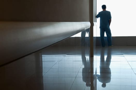 Surgeon looking through a window in a hospital
