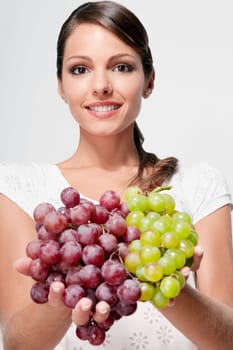 Portrait of a woman holding green and red grapes