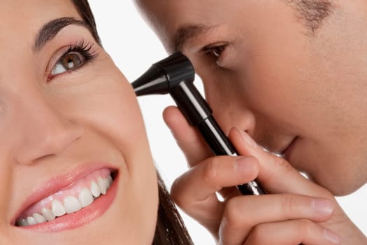 Doctor checking a womanŽs ear with an otoscope