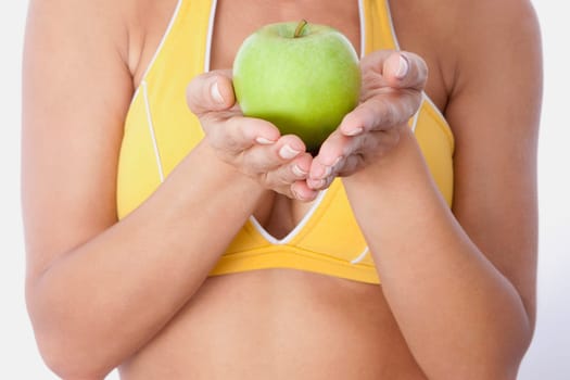 Mid section view of a woman holding a green apple