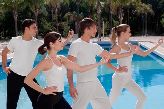 Four friends exercising at the poolside