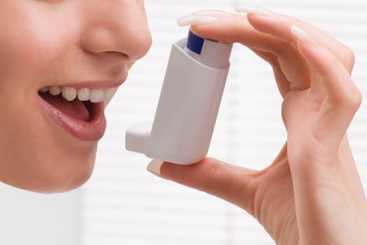 Woman using an asthma inhaler
