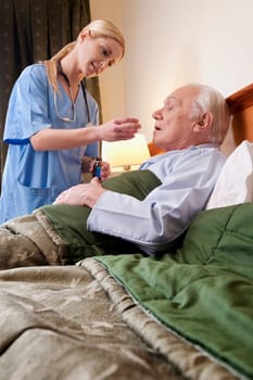 Female nurse giving medicine to a man