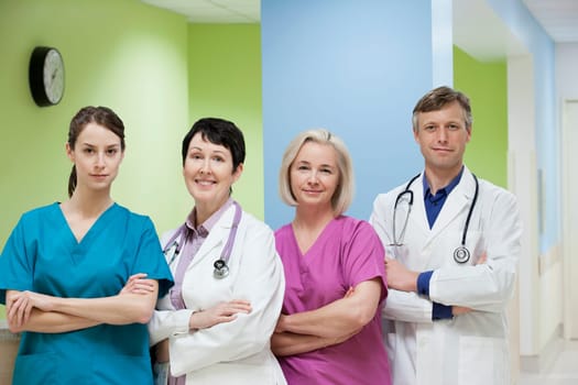Two doctors standing with two nurses and smiling