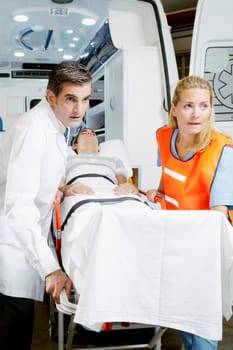 Paramedics pushing a patient on a gurney from an ambulance