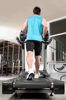 Rear view of a man walking on a treadmill