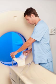 Healthcare worker examining a CAT scan machine