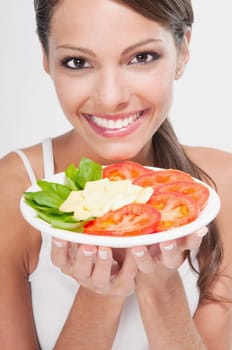 Woman holding a basil with tomato and cheese platter