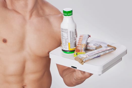 Mid section view of a man holding food supplements