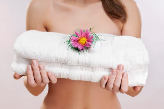 Mid section view of a woman holding towels with a flower