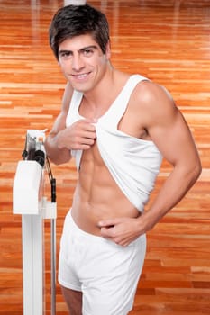 Portrait of a man pinching his waist and smiling