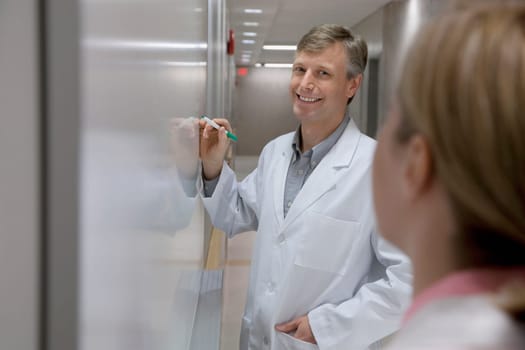 Doctor writing on a whiteboard in a hospital
