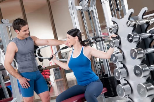 Male instructor helping a woman in exercising