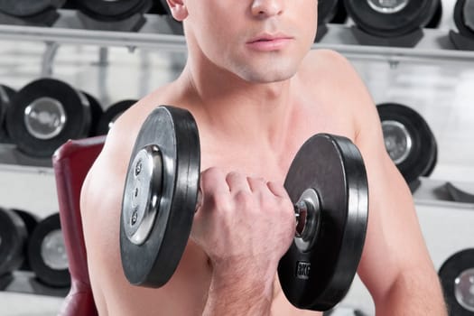 Man exercising with dumbbells in a gym