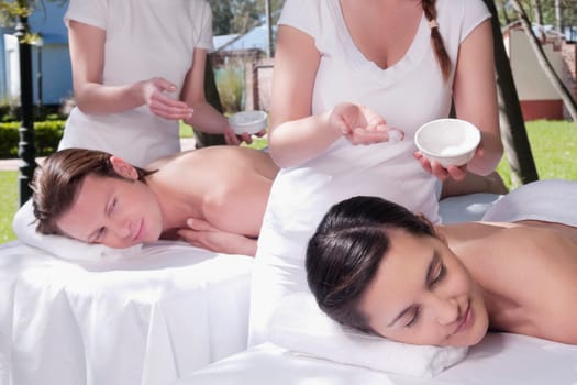 Couple receiving back massage from massage therapists