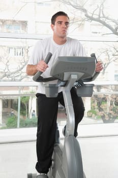 Man working out on an exercise bike in a gym