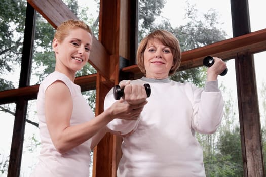 Physiotherapist helping a disabled woman in exercising