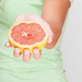 Close_up of a woman holding a grapefruit
