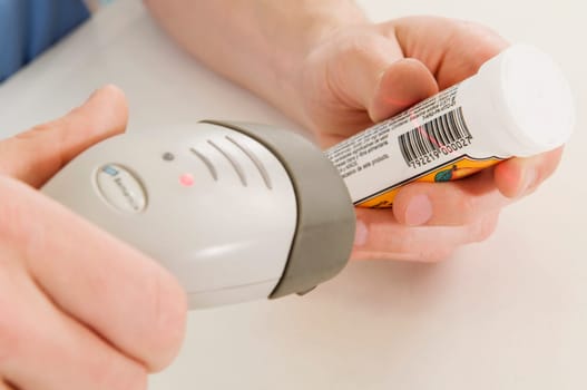 Sales clerk scanning the bottle price with a bar code reader
