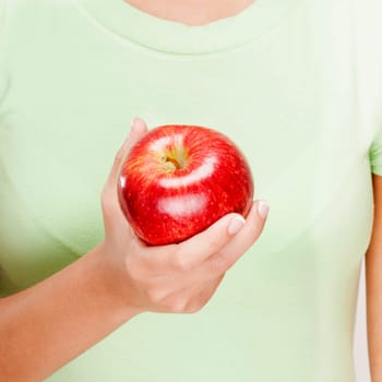 Mid section view of a woman holding a red apple