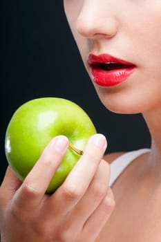 Close_up of a woman holding a granny smith apple