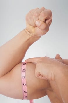 Man measuring his biceps with a tape measure