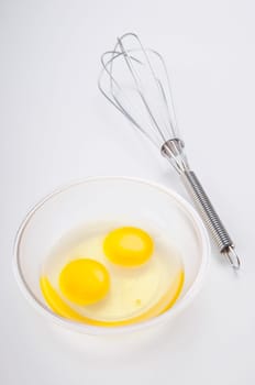 Close_up of a wire whisk and egg yolk in a bowl