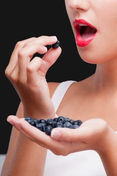 Close_up of a woman eating blueberries