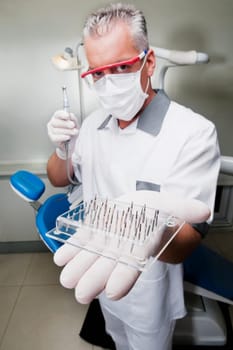 Dentist holding dental drill bits