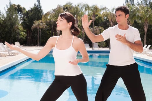 Couple exercising at the poolside