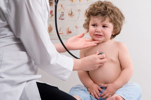 Female doctor examining a baby boy with a stethoscope