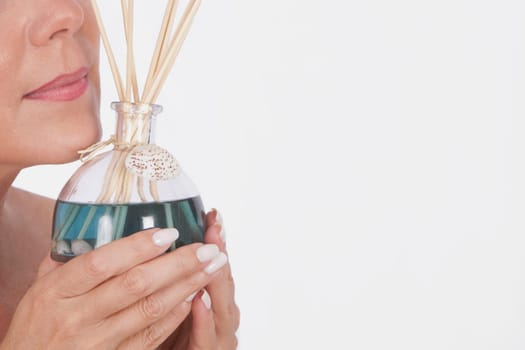 Woman holding an aromatherapy oil bottle with incenses