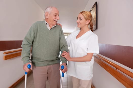 Nurse assisting a man to walk