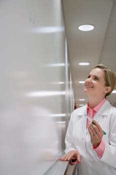 Female doctor writing on a whiteboard in a hospital