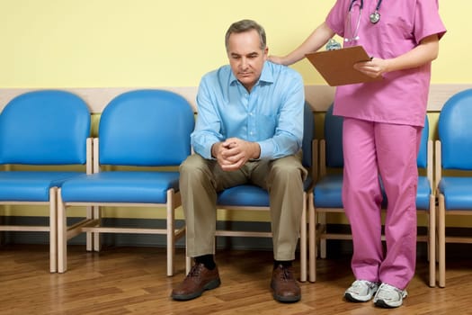 Female nurse consoling a patient in the waiting room